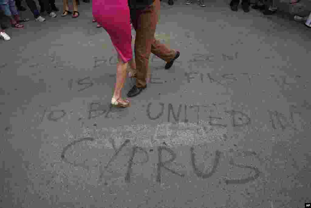 Greek and Turkish Cypriots dance a tango inside the United Nations-controlled buffer zone along Ledra Street in the medieval center of Cyprus&#39; divided capital Nicosia. The dancers gathered as part of a demonstration in support of talks aimed at reunifying the ethnically-divided island.