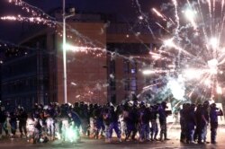 Fireworks are set off in front of police officers during anti-government protests that have been ignited by a massive explosion in Beirut, Lebanon, Aug. 10, 2020.