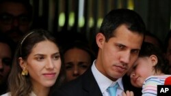 Presiden Sementara Venezuela, Juan Guaido, didampingi istrinya, Fabiana Rosales dan putrinya yang berusia 20 bulan, Miranda, mendengarkan pertanyaan wartawan saat konferensi pers di luar apartemen mereka, di Caracas, Venezuela, Kamis, 31 Januari 2019.