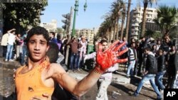 Un jeune manifestant montre sa main recouverte de sang, près de la Place Tahrir, le 18 décembre 2011