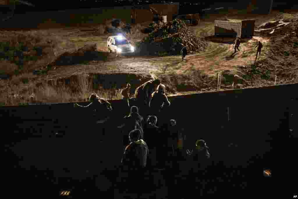 ជនចំណាក​មក​ពី​ ទីក្រុង​​ Tijuana ប្រទេស​ម៉ិកស៊ិក​ស្រុក​ឡើង​ជញ្ជាំង​​ព្រំដែន​ហើយ​លោត​ចូល​ក្នុងទឹកដី​​សហរដ្ឋអាមេរិក​ទៅ​ទីក្រុង​ San Diego កាលពី​ថ្ងៃទី​២៥ ខែធ្នូ ឆ្នាំ២០១៨។