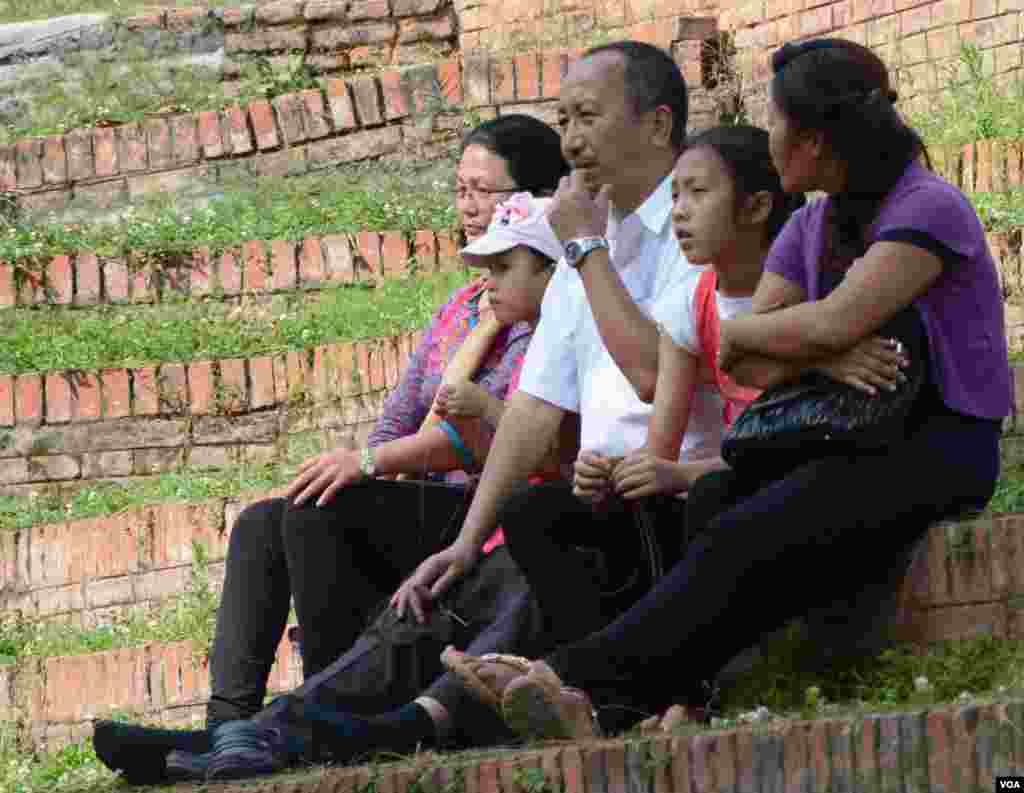 Well-known poet Shrawan Mukarung waits in an open space with his family after the quake, May 12, 2015. (Photo: Bikas Rauniar for VOA)