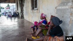 People wait on the outskirts of the seaport of Pemba on March 30, 2021 for the possible arrival of their families evacuated from the coasts of Afungi and Palma after the attack by armed forces against the city of Palma on March 24, 2021.