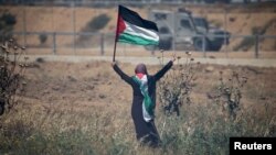 Isroil kuchlariga Falastin bayrog'i bilan qarshi chiqqan ayol, Isroil-G'azo chegarasi, 2019-yil, 15-may.
