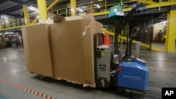 A robot carries boxes at the Amazon Fulfillment center in Robbinsville Township, New Jersey, Aug. 1, 2017. (AP Photo/Julio Cortez) 