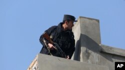 A member of the Afghan security force stands guard at the site of a suicide attack in Kabul, Afghanistan, Saturday, Nov. 28, 2015.