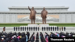 Attendees wearing face masks participate in an oath-taking meeting on Mansu Hill in Pyongyang, May 29, 2021.