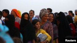 Para pengungsi Irak, yang melarikan diri dari kekerasan di Mosul, mengantre bantuan makanan di dalam kamp pengungsi Khazer, di luar kota Arbil, wilayah Kurdistan di Irak (29/6).