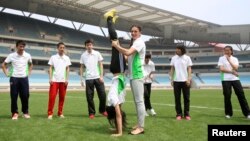 Atlet lompat galah Rusia Yelena Isinbayeva (depan, kanan), Duta Olimpiade Pemuda, membantu atlet muda China berlatih di pusat olahraga di Nanjing, tuan rumah Olimpiade Pemuda 2014. (Reuters/China Daily)
