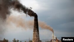 FILE - Smoke rises from the smokestacks of asphalt and brick factories burning coal, old shoes and oil extracted from tire rubber and plastic in Islamabad, Pakistan, March 9, 2017. 