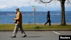 រូបឯកសារ៖ មនុស្ស​ពាក់ម៉ាស​នៅ​ពេល​ពួកគេ​ដើរ​នៅ​សួន Golden Gardens មួយថ្ងៃ​បន្ទាប់ពី​មជ្ឈមណ្ឌល​បង្ការ​ជំងឺ CDC បាន​ណែនាំ​ឱ្យ​មនុស្ស​ពាក់ម៉ាស​នៅ​ទីសាធារណៈ​អំឡុងពេល​មាន​ការផ្ទុះឡើង​នៃ​វីរុស​កូរ៉ូណា នៅ​ទីក្រុង Seattleរដ្ឋវ៉ាស៊ីនតោន សហរដ្ឋ​អាមេរិក កាលពី​ថ្ងៃ ទី៤ ខែមេសា ឆ្នាំ២០២០។