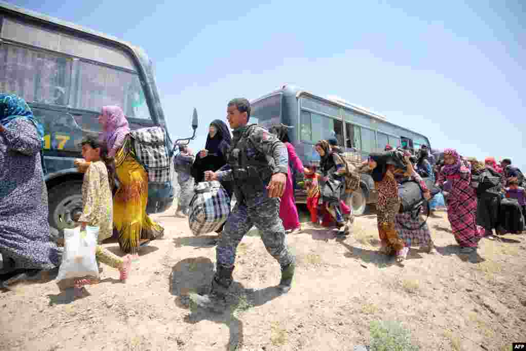 Iraqi forces help families near al-Sejar village in Anbar province after fleeing Fallujah on May 27, 2016, during a major operation to retake Fallujah from Islamic State.