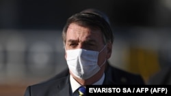 资料照：巴西总统贾尔·博尔索纳罗(Jair Bolsonaro)在巴西利亚阿尔沃拉达宫举行部长级会议前举行升旗仪式时戴着口罩。(2020年5月12日)