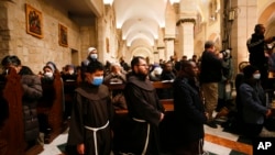 Anggota pendeta menghadiri Misa tengah malam Natal di Gereja Saint Catherine, di Gereja Kelahiran, di Betlehem, di Tepi Barat yang diduduki Israel, 25 Desember 2021. (Foto: via AP)