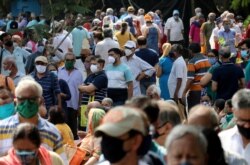 People wearing protective face masks wait to receive a vaccine for the coronavirus disease (COVID-19) at a vaccination center in Mumbai, India, Apr. 26, 2021.