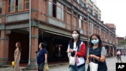 People wearing face masks to help curb the spread of the coronavirus walk on a street in Taipei, Taiwan, Oct. 19, 2020. (AP)