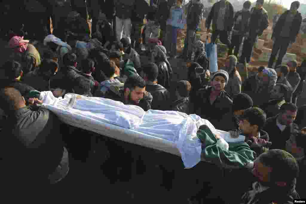 People carry the body of a civilian activist killed during what activists said was an ambush, during a funeral in eastern al-Ghouta, near Damascus, Nov. 24, 2013. 