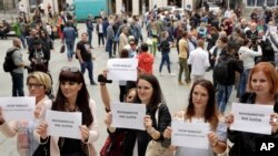 Bosnian journalists hold up banners reading "Journalism is not a crime" and "Stop violence against journalists," in downtown Sarajevo to protest the beating of a journalist in Banja Luka, the main city in the Serb-run part of Bosnia, Aug. 28, 2018.