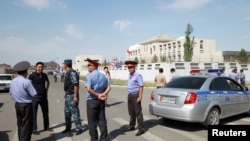 FILE - Investigators, interior ministry officers and members of security forces gather near the site of a bomb blast outside the Chinese Embassy in Bishkek, Kyrgyzstan, Aug. 30, 2016.