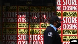 បុរស​ម្នាក់​ដើរ​កាត់​ហាង​ដែល​បាន​បិទ​ទ្វារ​ក្នុង​សង្កាត់​ Brooklyn ទីក្រុង​ញូវយ៉ក​កាលពី​ថ្ងៃទី០៥ ខែឧសភា ឆ្នាំ២០២០។