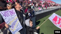 People hold signs at Women's March rally in Las Vegas, Sunday, Jan. 21, 2018. (C. Mendoza/VOA)