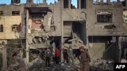 Warga Palestina berdiri di tengah puing-puing masjid dan bangunan yang runtuh akibat pemboman Israel di sekitar kota Rafah di selatan Jalur Gaza pada 24 Januari 2024. (Foto: AFP)