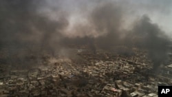 Fumées au dessus la vieille ville de Mossoul alors que les forces irakiennes poursuivent leurs combats contre les militants de l'État islamique à Mossoul, en Irak, le 3 juillet 2017. (AP / Felipe Dana)