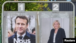 Des affiches de campagne du président français Emmanuel Macron, et de Marine Le Pen, candidate du parti d'extrême droite français Rassemblement National à Henin-Beaumont, France, 23 avril 2022.