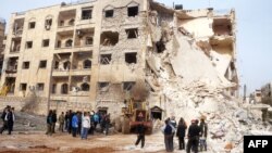 Syrians gather next to the scene of an explosion in Aleppo, January 18, 2013.