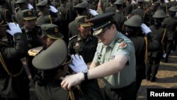 រូបឯកសារ៖ ទីប្រឹក្សា​កងទ័ព​ចិន​មួយ​រូប​បំពាក់​​​សក្តិ​ដល់​​និស្សិត​នាយ​ទាហាន​​​ដែល​បាន​បញ្ចប់​ការ​សិក្សា​​ ក្នុង​អំឡុង​ពិធី​មួយ​នៅ​​វិទ្យាស្ថាន​កងទ័ព​ជើង​គោក​នៅ​ក្នុង​ខេត្ត​កំពង់ស្ពឺ កាល​ពី​​ថ្ងៃ​ទី​១២ ខែ​មីនា ឆ្នាំ​២០១៥។