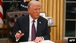 FILE - U.S. President Donald Trump signs an executive order on the U.S. withdrawal from World Health Organization in the Oval Office of the White House in Washington, on Jan. 20, 2025. 