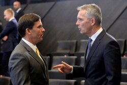NATO Secretary-General Jens Stoltenberg gestures as he talks to U.S. Secretary of Defense Mark Esper during a NATO defense ministers meeting in Brussels, Belgium, Oct. 25, 2019.