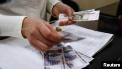 A cashier counts a pension payment in Russian roubles, in a post office at the Crimean city of Simferopol, March 25, 2014. 