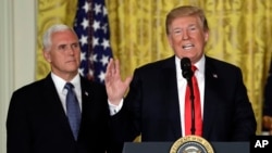 President Donald Trump speaks during a meeting of the National Space Council in the East Room of the White House, June 18, 2018, in Washington, as Vice President Mike Pence looks on. 