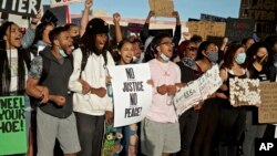 Demonstrators hold signs and shout in Portland, Ore., during a protest over the death of George Floyd, who died May 25 after being restrained by police in Minneapolis.