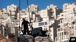 Une homme se tient devant un site de construction devant de nouvelles habitations dans un quartier de Jérusalem-Est, le 2 novembre 2011.