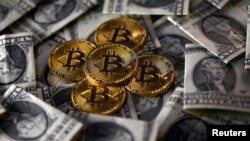 Bitcoin (virtual currency) coins placed on Dollar banknotes are seen in this illustration picture, Nov. 6, 2017. 