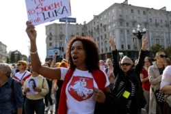 A woman wears a T-shirt with a sign of an old Belarusian flag during an opposition rally to protest the official presidential election results in Minsk, Belarus, Sept. 12, 2020.