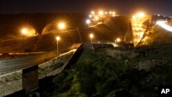 Floodlights from the U.S, illuminate multiple border walls, Jan. 7, 2019, seen from Tijuana, Mexico.