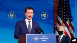 Former South Bend, Indiana, Mayor Pete Buttigieg, President-elect Joe Biden's nominee to be transportation secretary reacts to his nomination as Biden looks on during a news conference at The Queen theater in Wilmington, Delaware, Dec. 16, 2020.