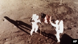 FILE - Apollo 11 astronauts Neil Armstrong and Edwin E. "Buzz" Aldrin, the first men to land on the moon, plant the U.S. flag on the lunar surface, July 20, 1969. (NASA)