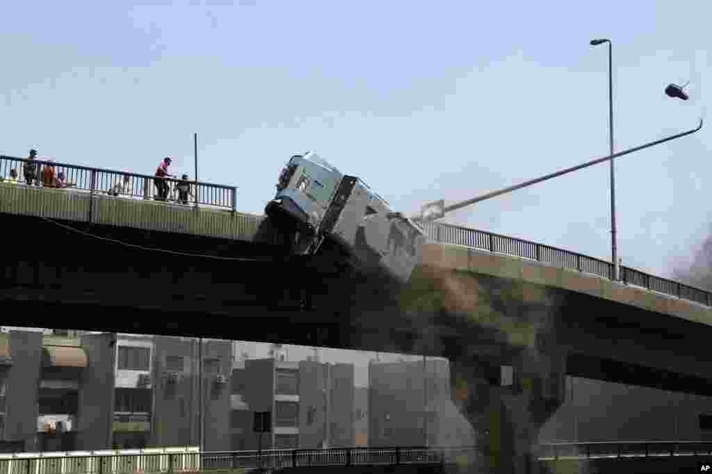 A police vehicle is pushed off of the 6th of October bridge by protesters close to the largest sit-in by supporters of ousted Islamist President Mohammed Morsi in the eastern Nasr City district of Cairo, Egypt, &nbsp;August 14, 2013.