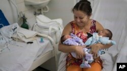 Severina Raimunda porte dans ses bars sa petite-fille Melisa Vitoria, à gauche, qui est né avec une microcéphalie et son frère jumeau Edison junior à l'hôpital de IMIP à Recife, dans l'Etat de Pernambuco, au Brésil, 3 février 2016. 
