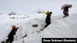Warga Afghanistan yang selamat dari longsoran salju membawa makanan untuk orang lain di Desa Abdullah Khil di Distrik Dara, Provinsi Panjshir, 1 Maret 2015. (Foto: REUTERS/Omar Sobhani)