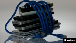 Foto ilustrasi ponsel-ponsel pintar yang dililit kabel jaringan internet, 7 Juni 20213. (Foto: Reuters)