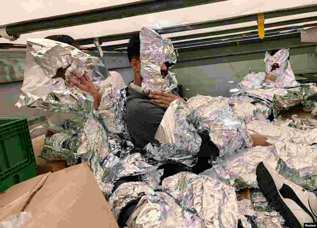 Iraqi refugees wrapped in aluminium foil to hide from an x-ray detector are pictured inside a truck at Pendik Port as they try to reach Italy in Istanbul, Turkey, June 6, 2018.