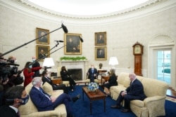 FILE - U.S. President Joe Biden and Vice President Kamala Harris meet with governors and mayors on his COVID-19 relief plan, in the Oval Office of the White House, Feb. 12, 2021.