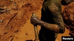 A garimpeiro uses a stick as an accelerator for a diesel engine while working a wildcat mine, also known as garimpo, at a deforested area of Amazon rainforest in Brazil, Aug. 6, 2017.