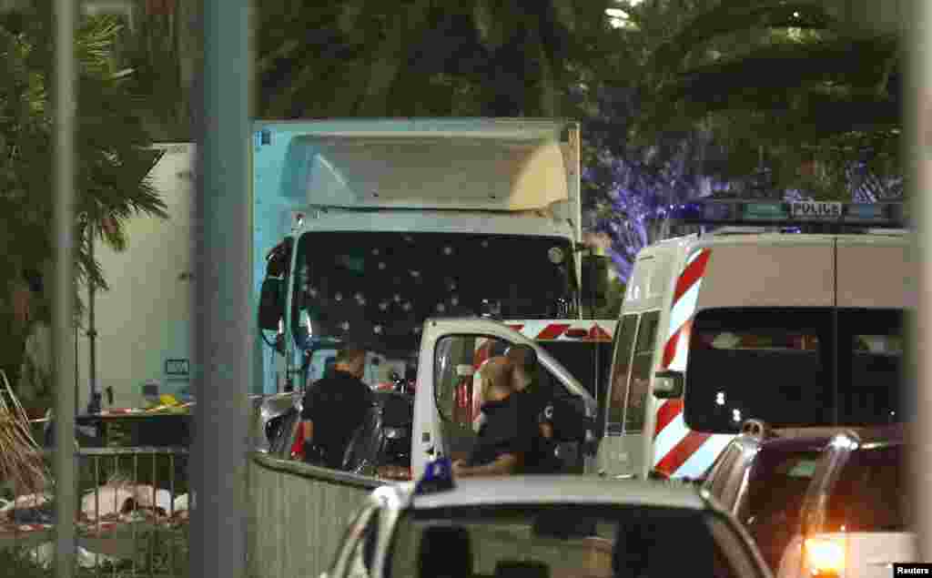 French police forces and forensic officers stand next to a truck that ran into a crowd celebrating the Bastille Day national holiday on the Promenade des Anglais killing at least 60 people in Nice, France, July 15, 2016.