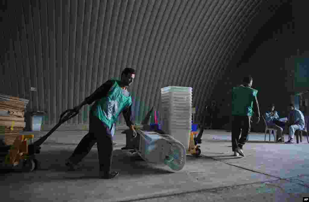 Afghan election workers in&nbsp;a warehouse&nbsp;carry ballot boxes and election materials, in Kabul, June 13, 2014.&nbsp;
